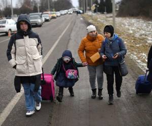 Con solo dos maletas en mano, esta familia camina en busca de refugió hacia la frontera de Polonia.