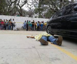El cuerpo de la víctima quedó tendido en el estacionamiento mientras lugareños llegaron al lugar para saber qué ocurrió.