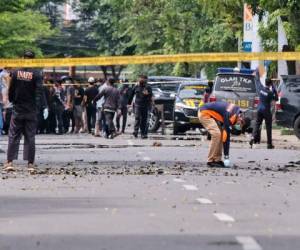 Policías inspeccionando la zona cerca de una iglesia donde se produjo una explosión en Makassar en el Sulawesi del Sur, Indonesia, el domingo 28 de marzo de 2021. (AP Foto/Masyudi S. Firmansyah).