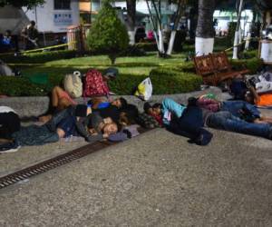 Al numeroso grupo de hondureños no le importa tener que dormir por las noches en el suelo del parque de Tecún Umán o esperar por horas bajo el sol por la tarjeta que les permita ingresar. Otros están considerando cruzar el río. (Foto: AFP)