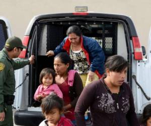 En esta fotografía del viernes 12 de abril, un agente de la Patrulla Fronteriza ayuda a mujeres migrantes con menores a salir de una camioneta para dejarlos afuera de la Misión de Socorro Gospel en Las Cruces, Nuevo México. (Blake Gumprecht/The Las Cruces Sun News vía AP)