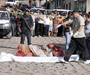Police investigators gather bags containing body parts in the capital city of Tegucigalpa, Honduras, Friday, Aug. 31, 2012. Several bags containing body parts were dumped in a street and police authorities have yet to announce how many bodies were found. Honduras has one of the highest murder rates in the world. (AP Photo/Fernando Antonio)