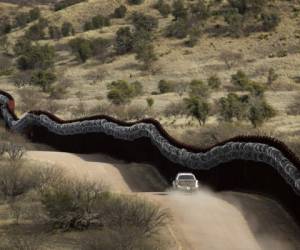 Fotografía de archivo del 2 de marzo de 2019 de agentes de la Oficina de Aduanas y Protección Fronteriza de Estados Unidos patrullando junto a una barrera cubierta de alambre de púas a lo largo de México, al oriente de Nogales, Arizona. Foto: AP