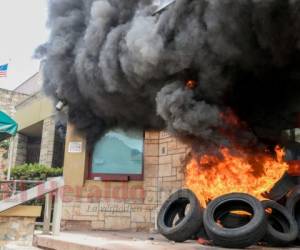 The entrance of the US embassy in Tegucigalpa burns after being set on fire by demonstrators of the education and health sectors protesting against government reforms, on May 31, 2019. - Thousands of teachers, doctors and students resumed their protests against government measures that thay say will privatize health and education services. (Photo by Orlando SIERRA / AFP)