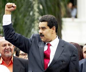 Venezuelan Vice-President Nicolas Maduro (C) raises his fist as the President of the Venezuelan National Assembly, Diosdado Cabello (R), looks on after a session of the national Assembly in Caracas on January 5, 2013. Maduro will take on as interim president after Venezuelan President Hugo Chavez's death on March 5, 2013, Venezuelan Minister of Foreign Affairs Elias Jaua informed. AFP PHOTO/Juan BARRETO
