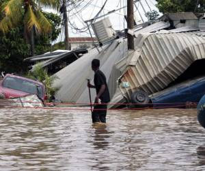 Varias zonas bajas del valle de Sula siguen inundadas este martes, ya que continúan las lluvias en el occidente del país. Foto: AP.