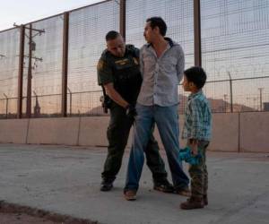 Un agente de Aduanas y Protección Fronteriza de los Estados Unidos registra a José, de 27 años, con su hijo José Daniel, de 6 años, en El Paso, Texas, Estados Unidos. Foto: AFP