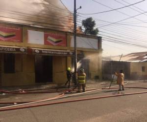 Miembros del Cuerpo de Bomberos tratan de controlar el siniestro que ya consumió la bodega.