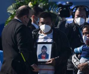 Los cuerpos llegaron en ataúdes a los que se les colocó encima una bandera azul y blanca de Guatemala, mientras que funcionarias de la cancillería vestidas de negro portaban fotografías de las víctimas. Entre sollozos, los familiares rodearon los féretros. Foto: AFP