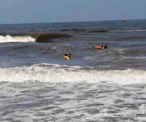 Las dos personas comenzaron bañando en la orilla de la playa, pero el fuerte oleaje los arrastró hacia el mar. Foto: Bomberos de Honduras.