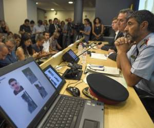 Josep Lluis Trapero, chief of the Catalan regional police 'Mossos D'Esquadra' (R), Interior Minister for the Catalan government Joaquim Forn (C) and Justice Minister of the Catalan Government Carles Mundo give a press conference in Barcelona on August 21, 2017.Spanish police said on August 21, 2017 that they have identified the driver of the van that mowed down pedestrians on the busy Las Ramblas boulevard in Barcelona, killing 13.The 22-year-old Moroccan Younes Abouyaaqoub is believed to be the last remaining member of a 12-man cell still at large in Spain or abroad, with the others killed by police or detained over last week's twin attacks in Barcelona and the seaside resort of Cambrils that claimed 14 lives, including a seven-year-old boy. / AFP PHOTO / LLUIS GENE