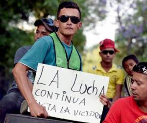 Un hondureño que participa en la caravana 'Migrant Viacrucis', sostiene un cartel que dice 'La lucha continúa hasta la victoria'. Foto AFP