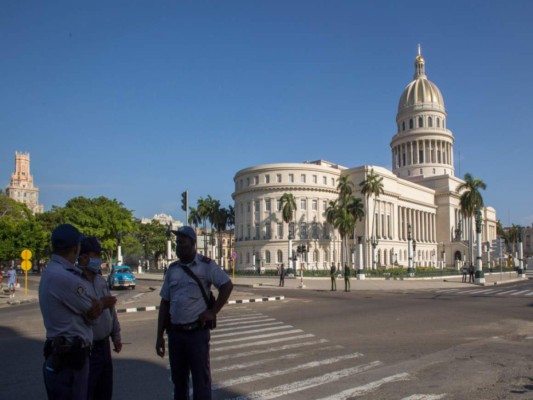 La policía monta guardia cerca del edificio del Capitolio Nacional en La Habana, Cuba, el lunes 12 de julio de 2021, un día después de fuertes protestas contra la escasez de alimentos y los altos precios en medio de la crisis del coronavirus. (AP Foto/Ismael Francisco).