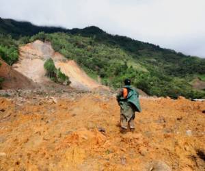 Un miembro de un equipo de rescate busca sobrevivientes en una zona donde se produjo un deslizamiento de tierra masivo por las lluvias ocasionadas por el paso de la tormenta Eta en la aldea de Queja, en Guatemala, el sábado 7 de noviembre de 2020.