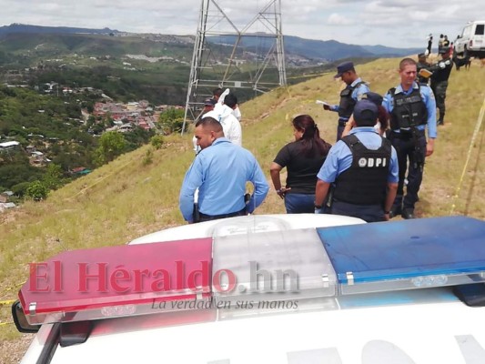 Elementos de la Dirección Policial de investigaciones (DPI) se desplazaron a la hondonada del sector 'F' de Los Pinos para realizar las indagaciones sobre el crimen. Foto: Estalin Irías/EL HERALDO.