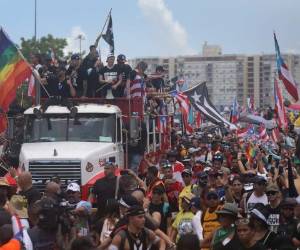 El camión que transporta al rapero Bad Bunny, al cantante Ricky Martin y al rapero Residente se une a miles de otras personas mientras llenan la autopista Expreso Las Américas para pedir la destitución del gobernador Ricardo Rosselló. Foto: Agencia AFP.