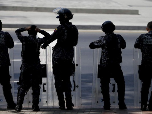 Policías venezolanos asumen posiciones antes de una marcha opositora en Caracas. Agencia AP.