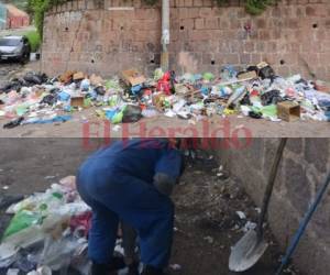 1) La acera de la calle se había convertido en el botadero de algunos vecinos que irresponsablemente lanzaban la basura en el lugar. 2) Personal de limpieza, armados de palas, escobas y otras herramientas, procedieron a retirar el promontorio de basura que estaba en la zona. Fotos: EL HERALDO