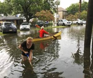 Personas realizan trabajos de limpieza después de una intensa tormenta en el vecindario Broadmoor de Nueva Orleans. Foto: AP.