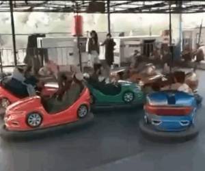 Los talibanes se divierten en los carros chocones de un parque.