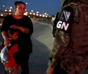 Un oficial de la Policía Militar con la insignia de la nueva Guardia Nacional de México detiene a migrantes guatemaltecos para evitar que crucen de Ciudad Juárez, México a El Paso, Texas. Agencia AP.