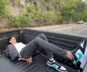 Captura de pantalla de un video que muestra al presunto conductor del vehículo dormido dentro de la paila de la patrulla tras ser detenido.