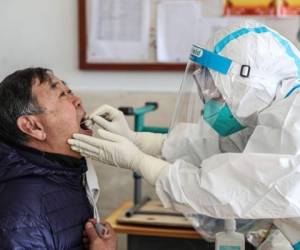 Un trabajador médico toma una muestra de hisopo de un residente para realizar la prueba del coronavirus covid-19 en Shenyang, en la provincia de Liaoning, en el noreste de China, el 31 de diciembre de 2020. Foto: AFP