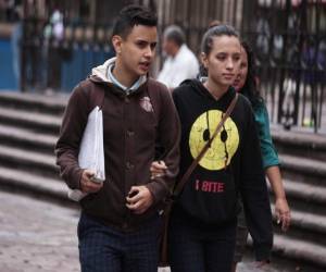 Dos jóvenes transitan abrigados por el parque Central de Tegucigalpa. (Fotos: Ronald Aceituno)