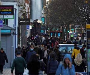 Los peatones, algunos con mascarilla o cubiertos debido a la pandemia de covid-19, pasan frente a las tiendas cerradas en Oxford Street en el centro de Londres el 20 de diciembre de 2020. Foto: AP