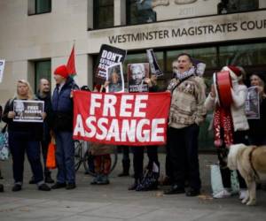 Seguidores del fundador de WikiLeaks, Julian Assange, con un cartel que dice 'liberen a Assange', están concentrados frente a la Corte de Magistrados de Westminster para darle apoyo durante una audiencia administrativa de su causa de extradición, Londres, jueves 26 de noviembre de 2020.