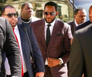 En esta foto del 26 de junio del 2019, el cantante de R&B R. Kelly, en el centro, llega a la Corte Penal de Leighton para responder a delitos de abuso sexual en Chicago. Kelly, quien ya enfrenta cargos de abuso sexual en Illinois, fue arrestado en Chicago el jueves 11 de julio del 2019 bajo un acta de un jurado de instrucción federal que incluye 13 cargos, entre ellos crímenes sexuales y obstrucción de la justicia. (AP)