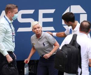 Tras impactarle un pelotazo, Djokovic se acercó a ver como se encontraba tras el incidente que le costó su descalificación. Foto: AFP