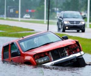 Un vehículo abandonado se ve medio sumergido en una cuneta junto a una autopista casi inundada, bajo los aguaceros del huracán Ida el domingo 29 de agosto de 2021, en Bay Sain Louis, Mississippi. FOTO: AP