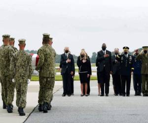 El presidente Joe Biden observa a mientras elementos de la Marina cargan el féretro con los restos del cabo de la marina Maxton W. Soviak, de 22 años, el domingo 29 de agosto de 2021, en la base aérea Dover, en Delaware. (AP Foto/Manuel Balce Ceneta)