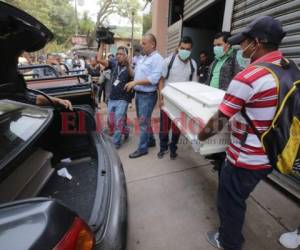 Triste escena. El ataúd de Ashley Daniela es cargado por dos parientes, mientras el de su hermanita Angelí Michelle la espera en el vehículo. Al fondo -en otro carro- se observa el féretro de Herminia. (Foto: Estalin Irías/El Heraldo)