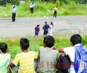 La imagen muestra a un grupo de niños expectantes frente a una escena del crimen en la capital. Foto Estalin Irías| EL HERALDO