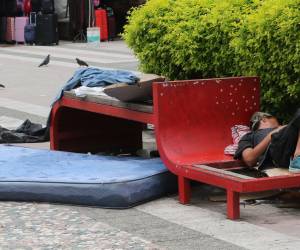 Colchones, cartones y ropa vieja cubren las bancas de la plaza, donde viven decenas de personas sin techo ante la vista y el temor de los capitalinos