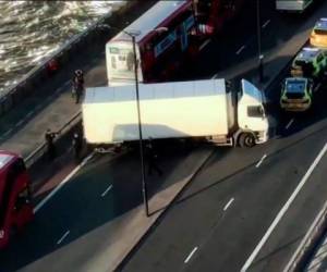 Policías rodean un camión que bloquea el Puente de Londres tras el ataque de este viernes en Londres. Foto AP