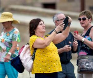 A tourist uses a phone to take pictures while on a visit to Luxor Temple in Egypt's southern city of Luxor on March 9, 2020. - Egypt on March 8 reported the country's -- and Africa's -- first fatality from the virus, a 60-year-old German tourist who died in a Red Sea resort in eastern Egypt. The following day, Egypt's health ministry said the total number of known cases had risen to 55. Scores of foreign tourists, including US French and Indian nationals, and Egyptian crew Monday remained quarantined aboard a Nile River cruise ship from which 45 suspected coronavirus cases have been evacuated, passengers aboard told AFP. (Photo by - / AFP)