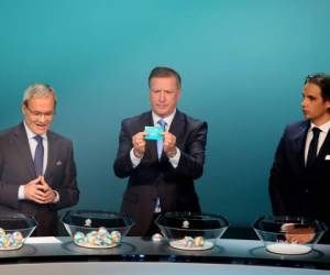 El secretario general de la UEFA, Giorgio Marchetti (izquierda), el exjugador Ronnie Whelan (centro) y Nuno Gomes (derecho) en el sorteo de la Euro2020. Foto: AFP