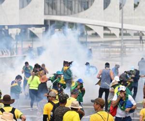 Partidarios de Bolsonaro chocan con la policía afuera del Congreso de Brasil momentos antes de irrumpir en el recinto legislativo.