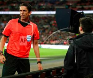 El árbitro Deniz Aytekin consulsa el videoarbitraje (VAR) antes de conceder un penal a Italia durante el partido amistoso frente a Inglaterra en el estadio Wembley de Londres. Foto AP/ EL HERALDO