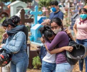 Los familiares y amigos de un mecánico, quien murió en un hospital con síntomas del nuevo coronavirus, lloran en el cementerio Milagro de Dios en Managua. Foto: AFP.