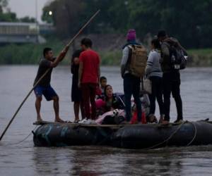 Migrantes y viajeros cruzan el río Suchiate, que marca la frontera entre Guatemala y México, desde Tecun Uman, Guatemala, domingo 6 de junio de 2021. (AP Foto/Moises Castillo)