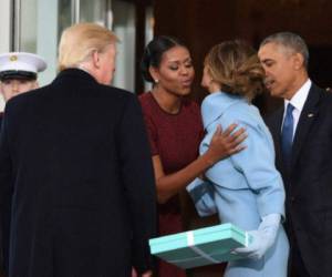 Momento en el que Melania saluda a Michelle Obama y entrega el misterioso e inusual regalo.