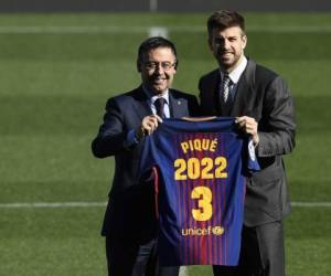 Gerard Piqué mostrando orgulloso su camisa como señal de su contrato con el FC Barcelona hasta 2022. (AFP)