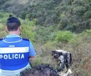 Un agente de la Policía Nacional observa el vehículo tras el accidente.