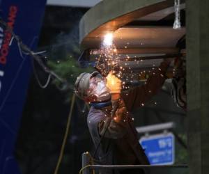 Un operario, con mascarilla para protegerse del coronavirus, suelda un trozo de metal en una obra en Seúl, Corea del Sur, el 21 de agosto de 2020.