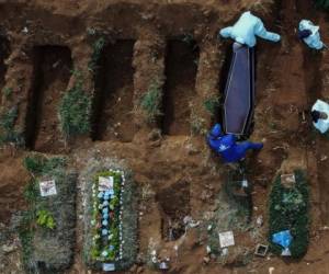 Foto aérea que muestra a los sepultureros enterrando a una supuesta víctima de COVID-19 en el cementerio de Vila Formosa, en las afueras de Sao Paulo, Brasil. Foto AFP