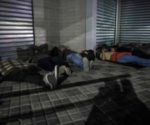 Los migrantes salvadoreños descansan antes de unirse a la caravana que se dirige a los EE. UU., En San Salvador. (Foto: AFP)